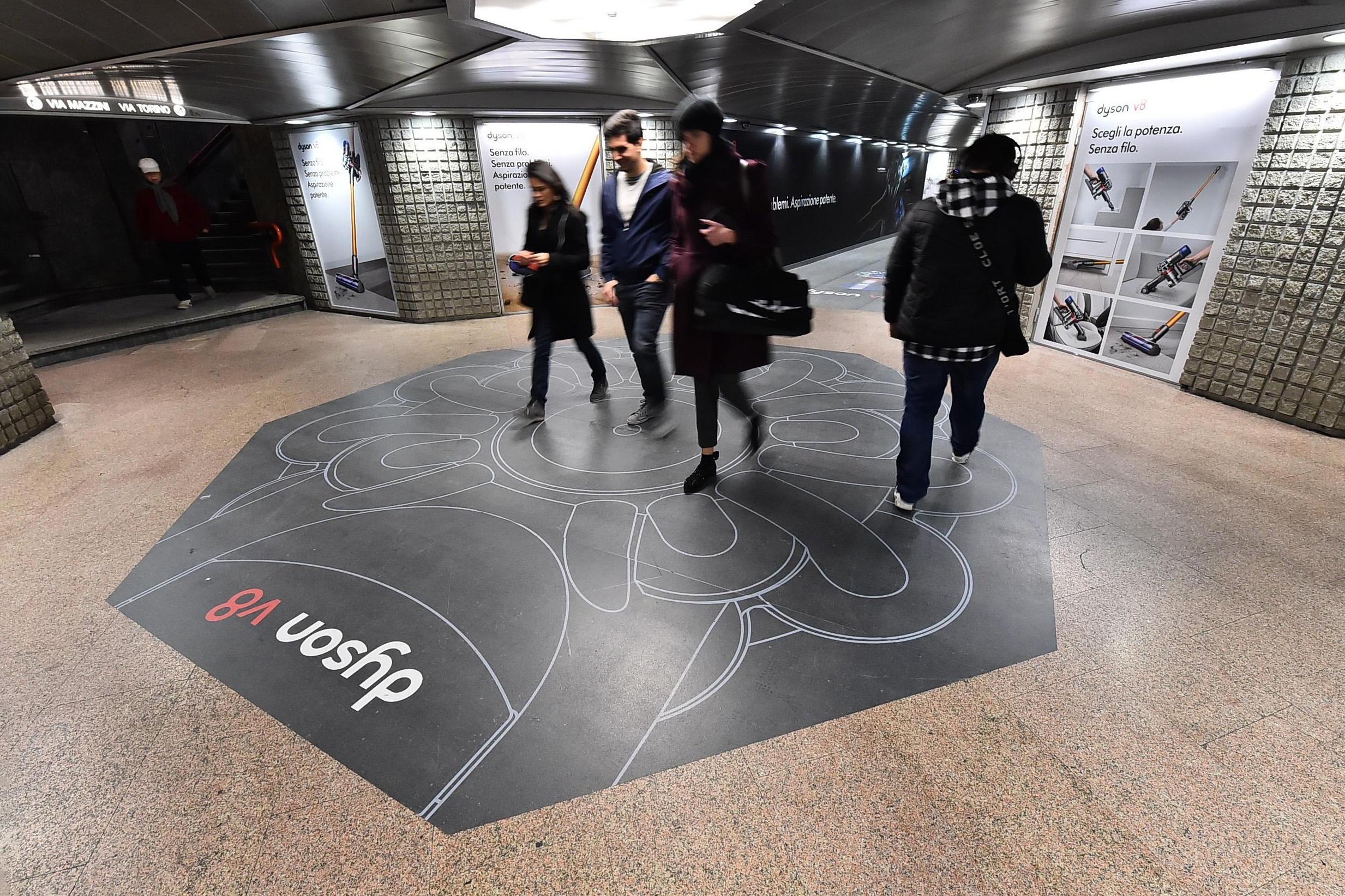 Dyson V8 out-of-home advertising campaign featuring a striking floor design in a busy subway station. - Alexi Hall